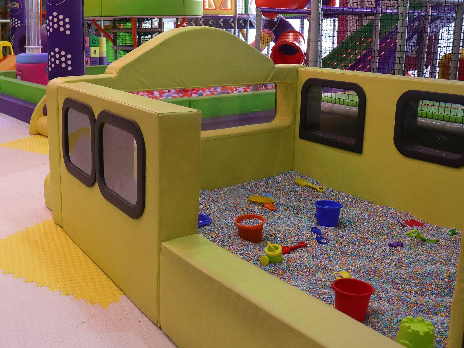 Bus-shaped kinetic sand play pit in the toddler sensory zone at Little Peppe Aluva